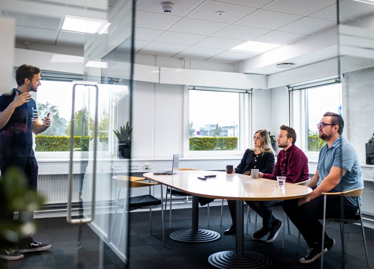 Benjamin står foran skærm og holder oplæg