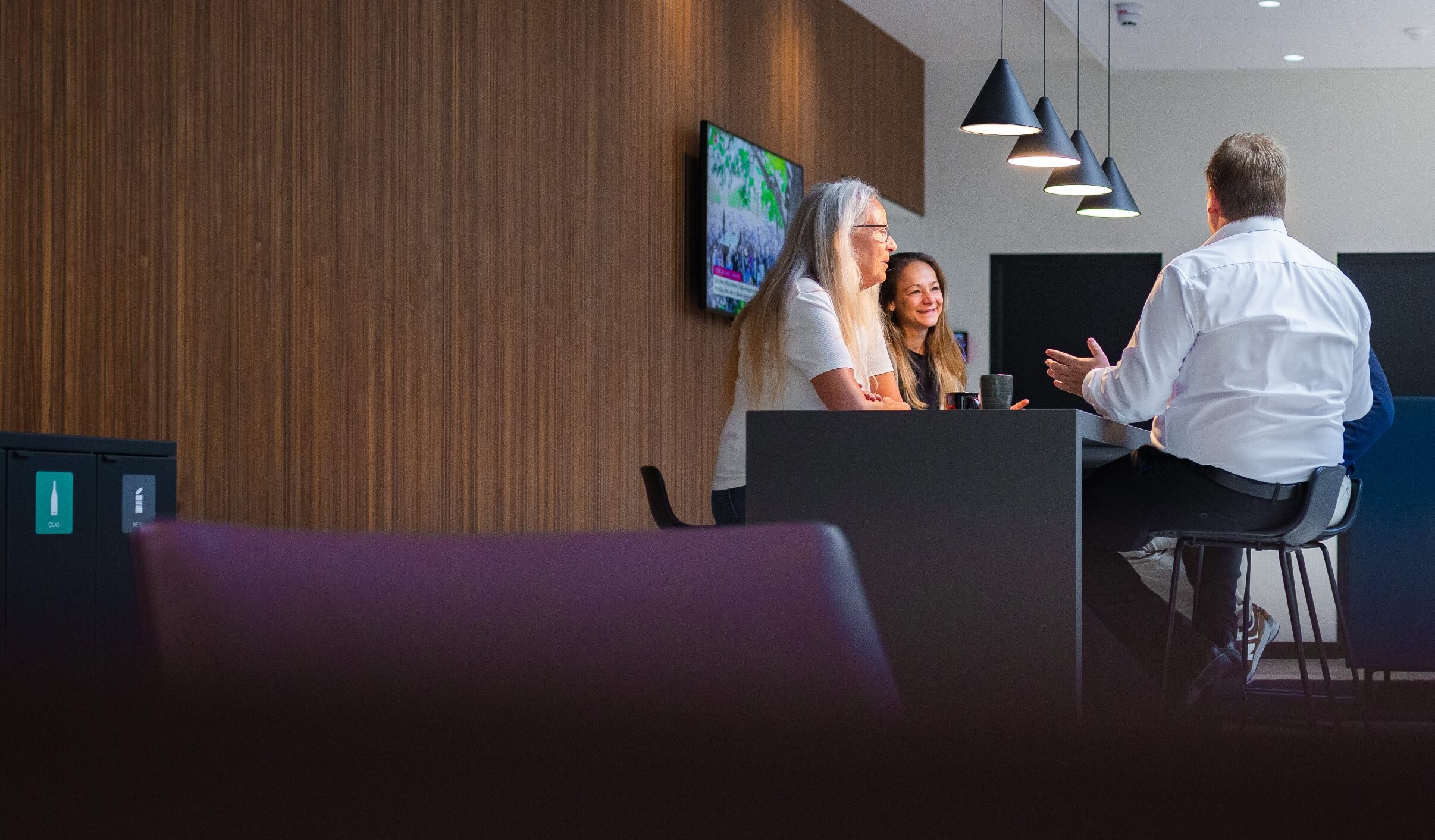 Gruppe medarbejder snakker sammen ved et bord på afdelingen