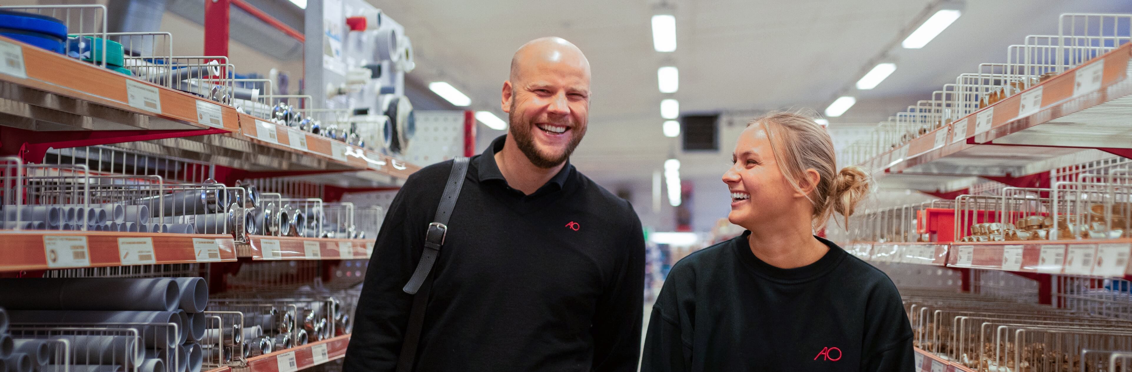 Billede to AO-medarbejder, som går smilende rundt i AO butik