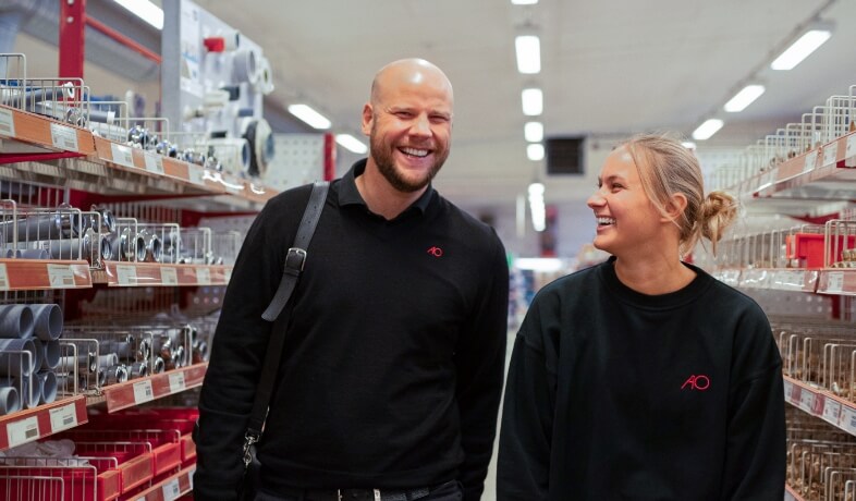 GBillede to AO-medarbejder, som går smilende rundt i AO butik