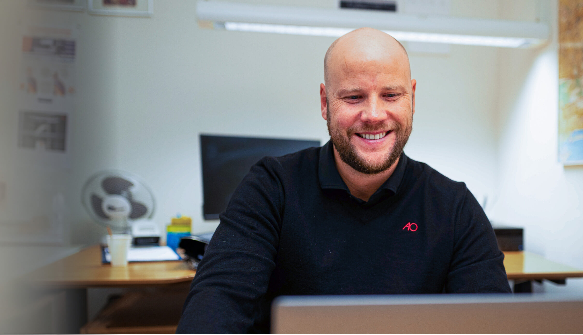 Billede af Bo der sidder smilende foran skrivebord